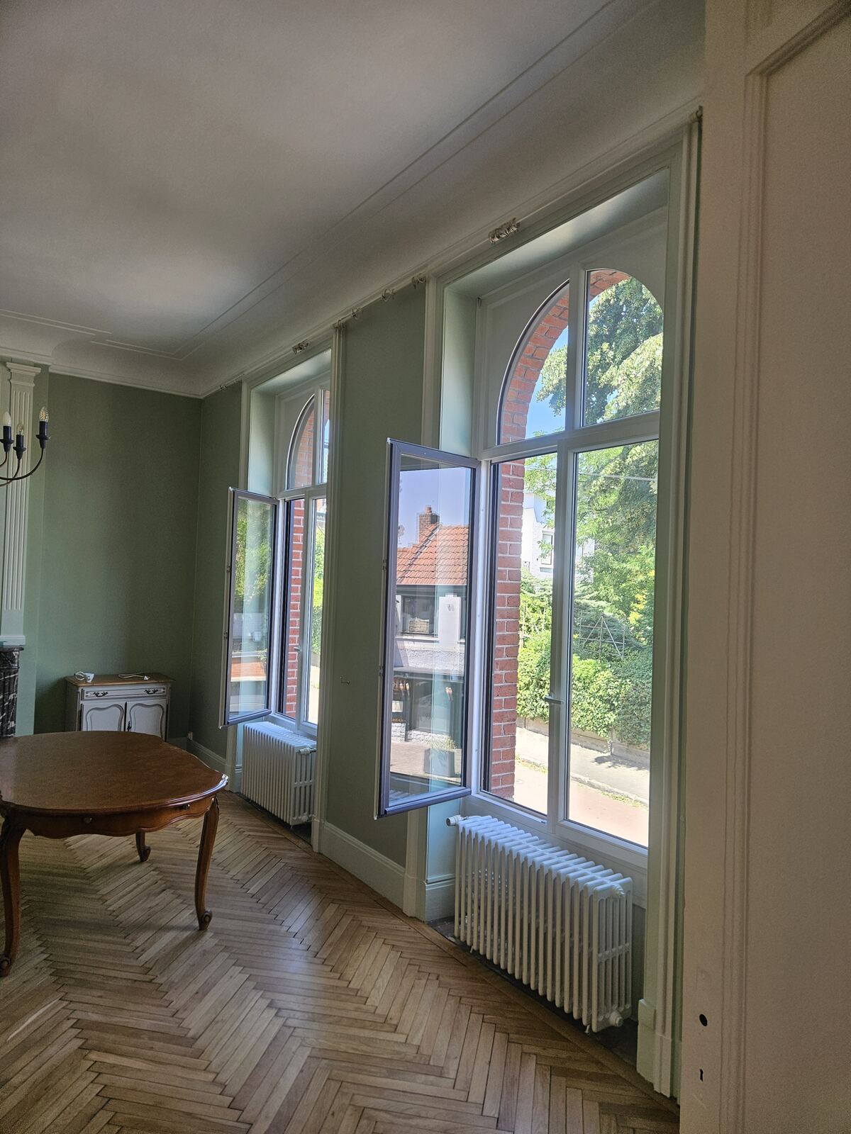 Pièce vert sauge avec grandes fenêtres cintrées
