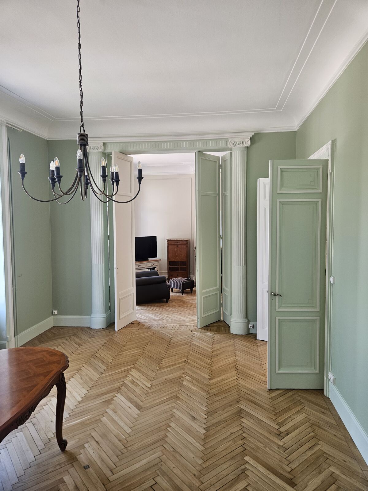 Pièce vert sauge avec portes ouvertes en enfilade